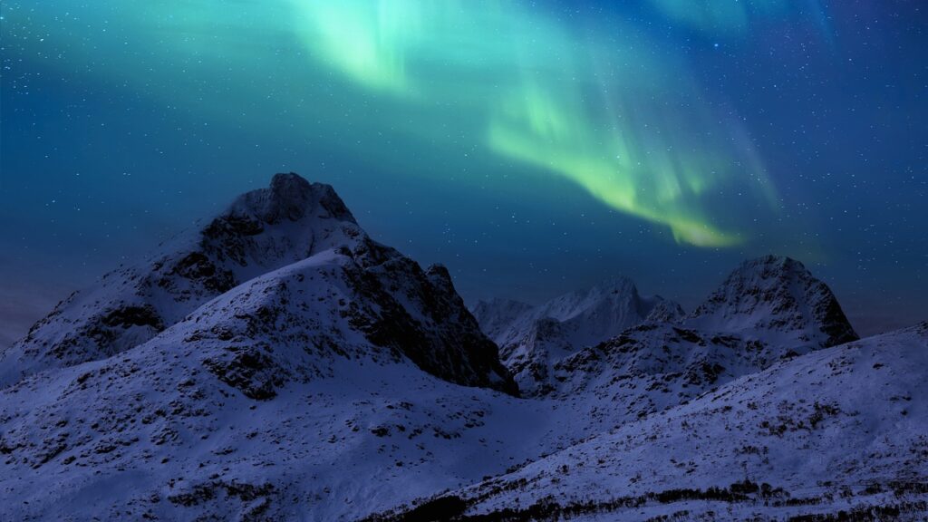 Fjell med aurora borealis i bakgrunnen.